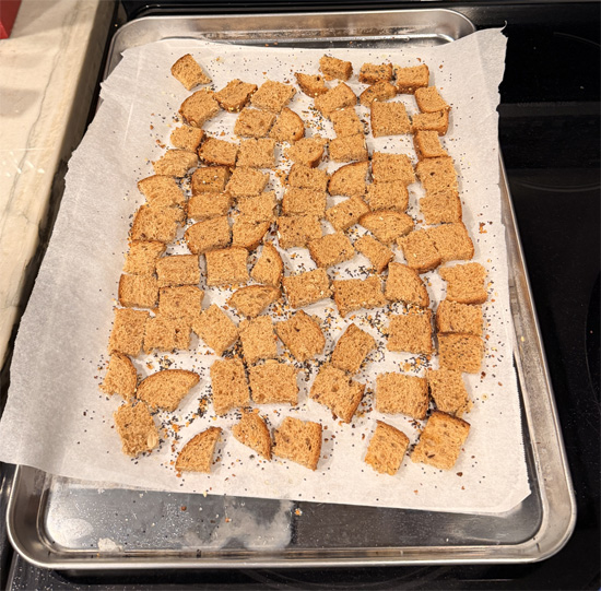 Cut the bread into small 1 inch squares. Spread the bread squares on the prepared baking sheet. Spray with olive oil and sprinkle with 1 Tbsp Everything Bagel seasoning. Bake 8 minutes, flip, spray again, and bake another 8 minutes until crunchy. Set croutons aside.