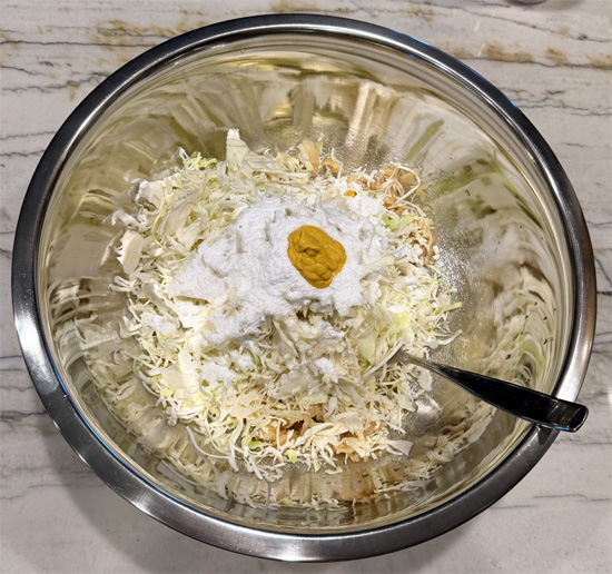 In a large bowl, combine the sauerkraut, coleslaw, vinegar, sweeteners, mustard, both cheeses, and remaining 1 Tbsp Everything Bagel seasoning. Mix well.