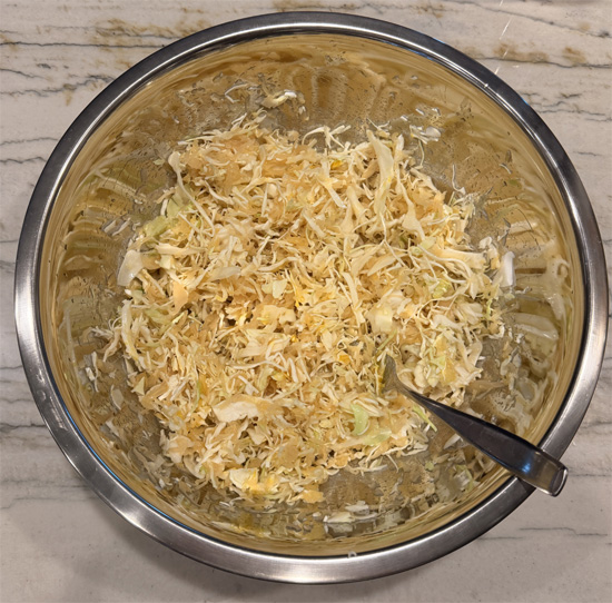 In a large bowl, combine the sauerkraut, coleslaw, vinegar, sweeteners, mustard, both cheeses, and remaining 1 Tbsp Everything Bagel seasoning. Mix well.