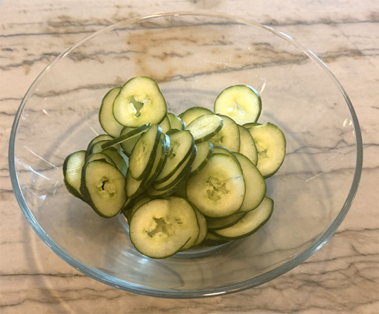 Prep the salad: Thinly slice the cucumber and place in a large bowl. For a less chewy texture, peel the cucumber before slicing.