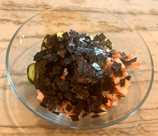 Chop imitation crab and add to the bowl along with the seaweed wraps, cut into small pieces. Toss to combine.