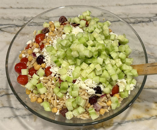 After cooling, add feta, cucumbers, parsley, mint, dill, and the remaining dressing. Toss to combine and serve.
