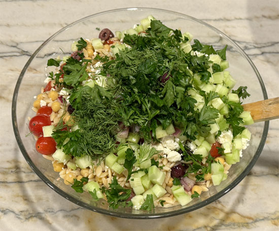 After cooling, add feta, cucumbers, parsley, mint, dill, and the remaining dressing. Toss to combine and serve.