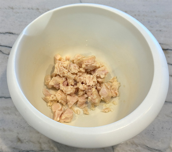 Drain chicken and place in a bowl. Add buffalo sauce, garlic powder, pepper and cream cheese. Mix well with a fork.