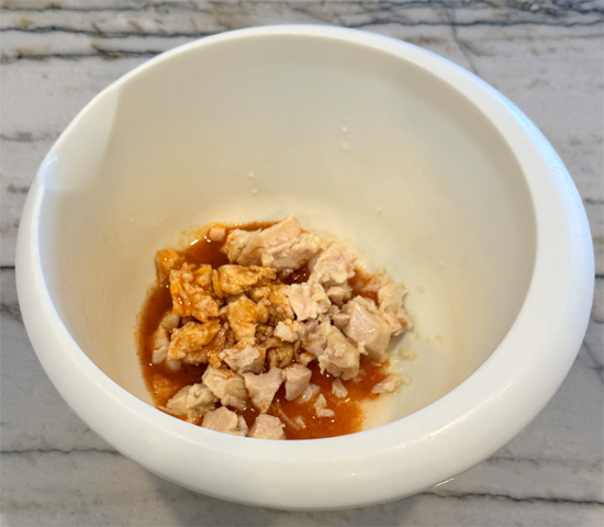 Drain chicken and place in a bowl. Add buffalo sauce, garlic powder, pepper and cream cheese. Mix well with a fork.
