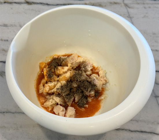Drain chicken and place in a bowl. Add buffalo sauce, garlic powder, pepper and cream cheese. Mix well with a fork.