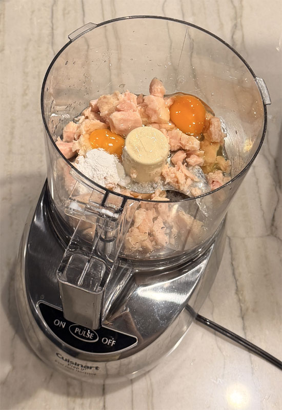 Place chicken or tuna in a food processor. Add eggs and baking powder.