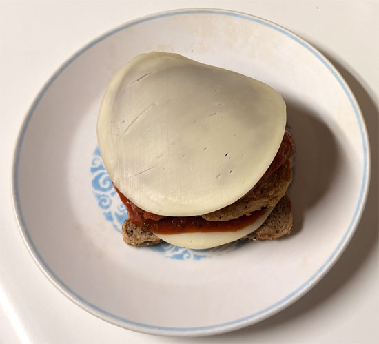 Assemble the sandwich: one slice of bread butter side down, a slice of provolone, 2 tablespoons marinara, the chicken patty, 2 more tablespoons marinara, the second slice of provolone, and the last slice of bread butter side up.