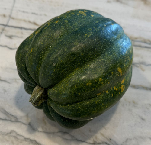 Wash the squash thoroughly and slice off the top and bottom. Then, place it on a flat end and cut it vertically in half. Remove the seeds with a spoon, rinse and pat dry. 