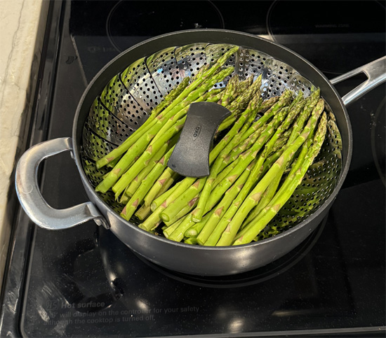 Once the water is boiling, reduce the heat to medium. Place the asparagus in the steamer basket, cover with a lid, and steam for 5-8 minutes, depending on the thickness of the stalks and how tender you want them.
