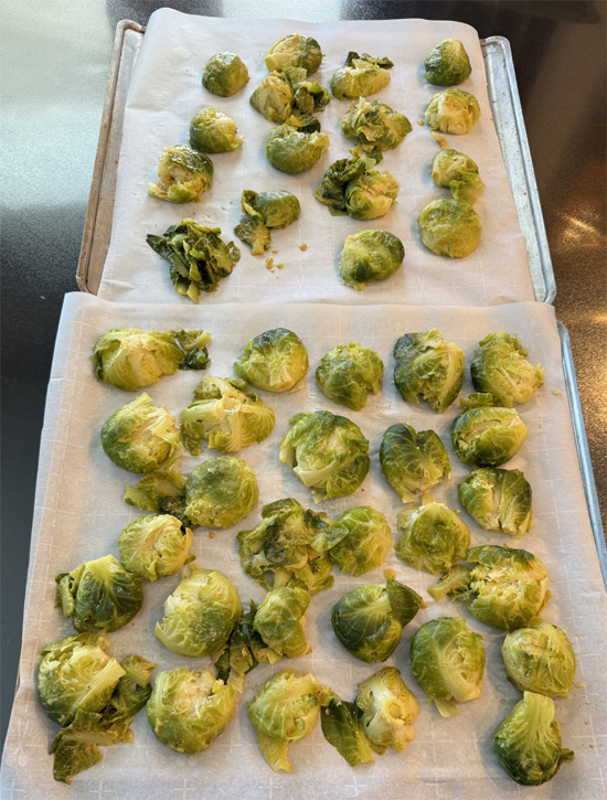 Lay a piece of parchment paper on a baking sheet. Then, put the Brussels sprouts on the sheet and smash them gently but firmly. 