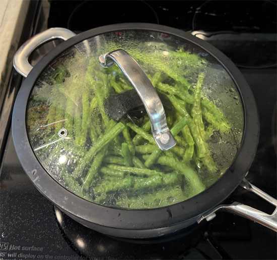 Once the water is boiling, place the steamer basket in the pot, add the green beans, and cover with a lid. Steam for about 15 minutes, or until the beans are tender.
