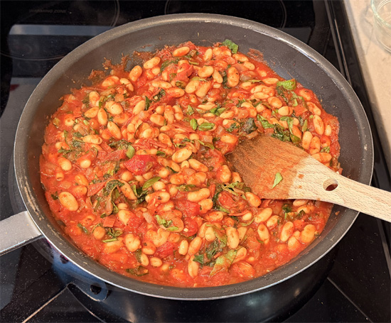 Stir in the basil, salt and pepper. Reduce heat to low and simmer gently for 5 minutes.