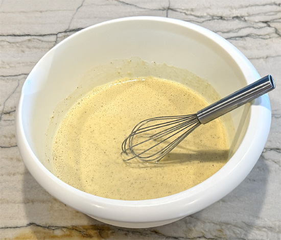 Whisk the beer into the batter. Then dip the cauliflower into the batter and then into the breadcrumb mixture. Place the pieces on the greased baking sheet. Then lightly drizzle the olive oil over top of the cauliflower.