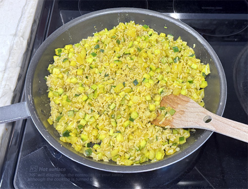 Once the rice is fully cooked, add the rice to the skillet and gently fold everything together, ensuring the grains are evenly coated with the spices and mixed with the vegetables.