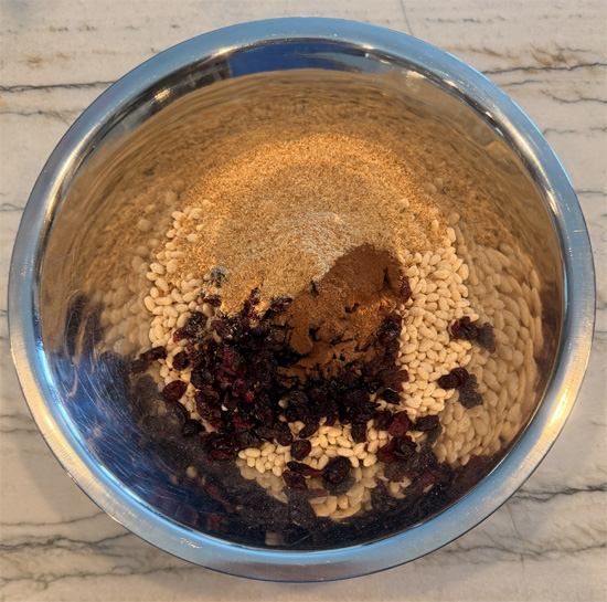 In a large bowl, stir together the quick-cooking oats, rice crisps, dried cranberries, flaxseed meal, cinnamon and nutmeg until evenly mixed.