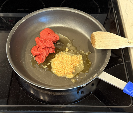 Put the olive oil, garlic and tomato in the pan and mix together, cooking for about 3 minutes. 