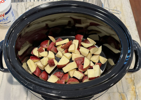 Chop the potatoes and onion, mince the garlic, and then put them into the pot.