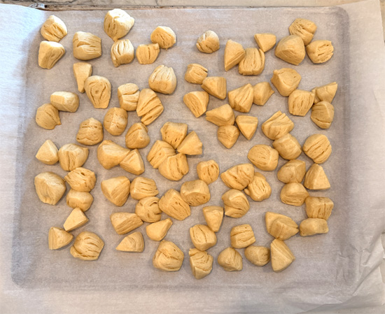 Cut each biscuit into 8 small pieces and place the dough on a parchment lined baking sheet. Bake them for 8-10 minutes, until lightly browned.
