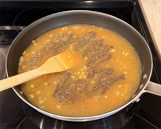 Pour in the chicken bone broth. Add black pepper, dried basil, Italian seasoning, and red pepper flakes. Stir to combine and bring to a gentle simmer.