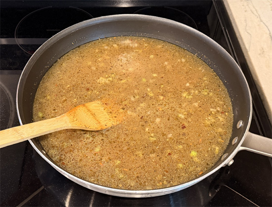 Pour in the chicken bone broth. Add black pepper, dried basil, Italian seasoning, and red pepper flakes. Stir to combine and bring to a gentle simmer.