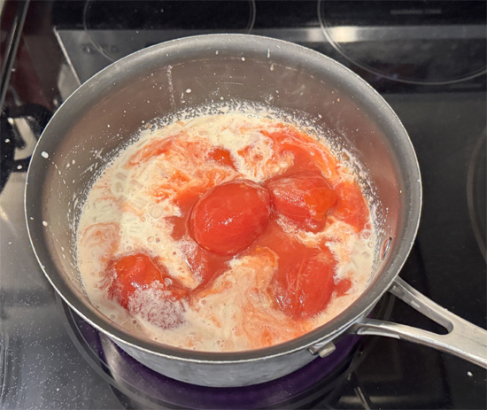 Add the tomatoes and their juices. Use a potato masher to crush them. Then stir in the drained lentils and salt.